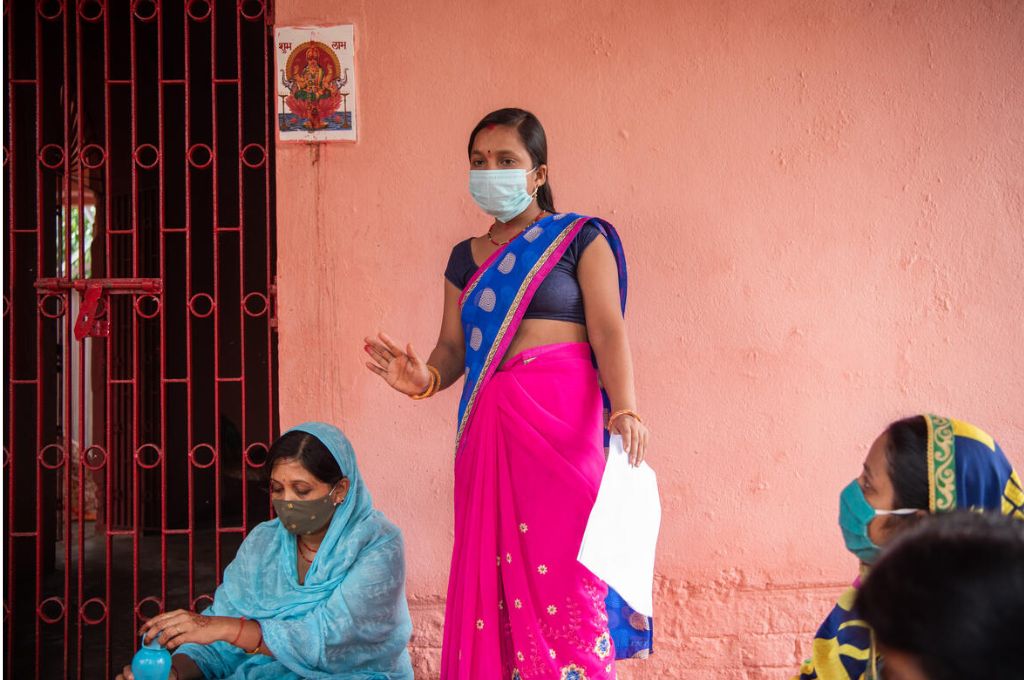 A woman field surveyor addressing other women sitting around her