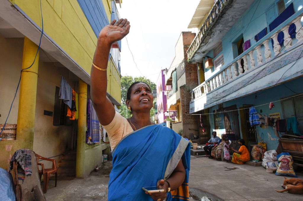 A woman in a saree standing, waving to somebody_FCRA