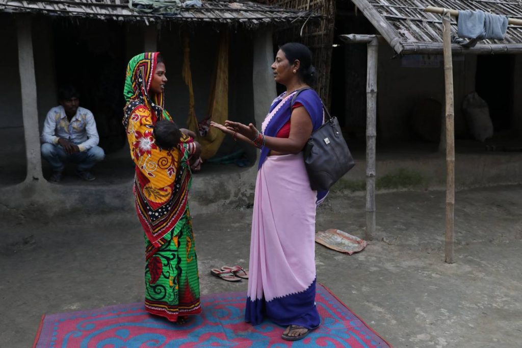 frontline health worker talking to a woman--frontline health workers