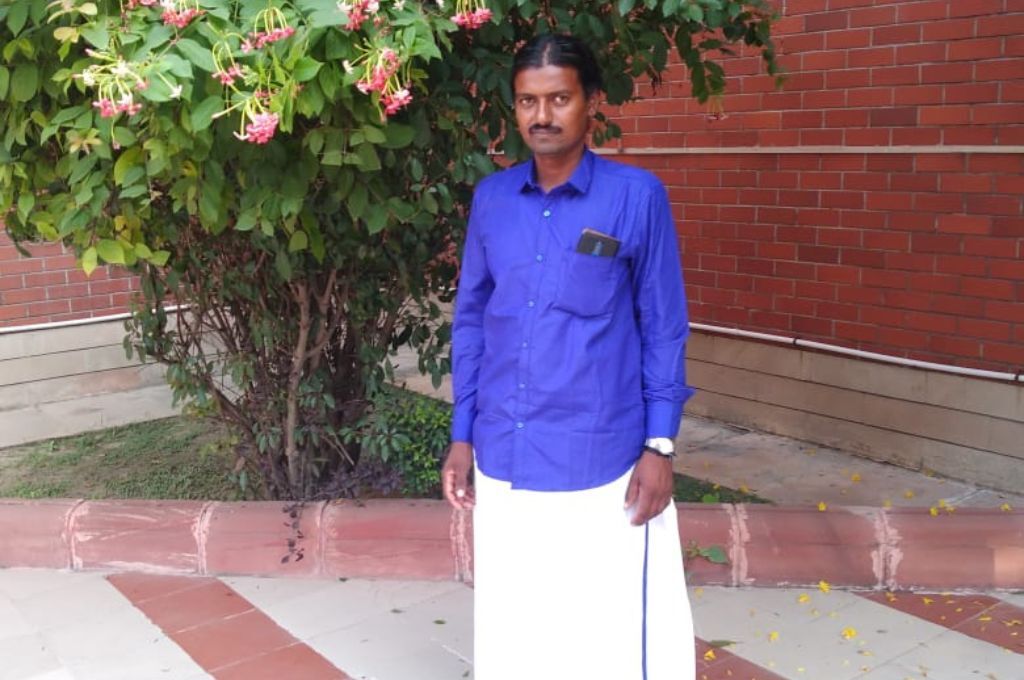 Man standing with a tree in the background-bonded labour