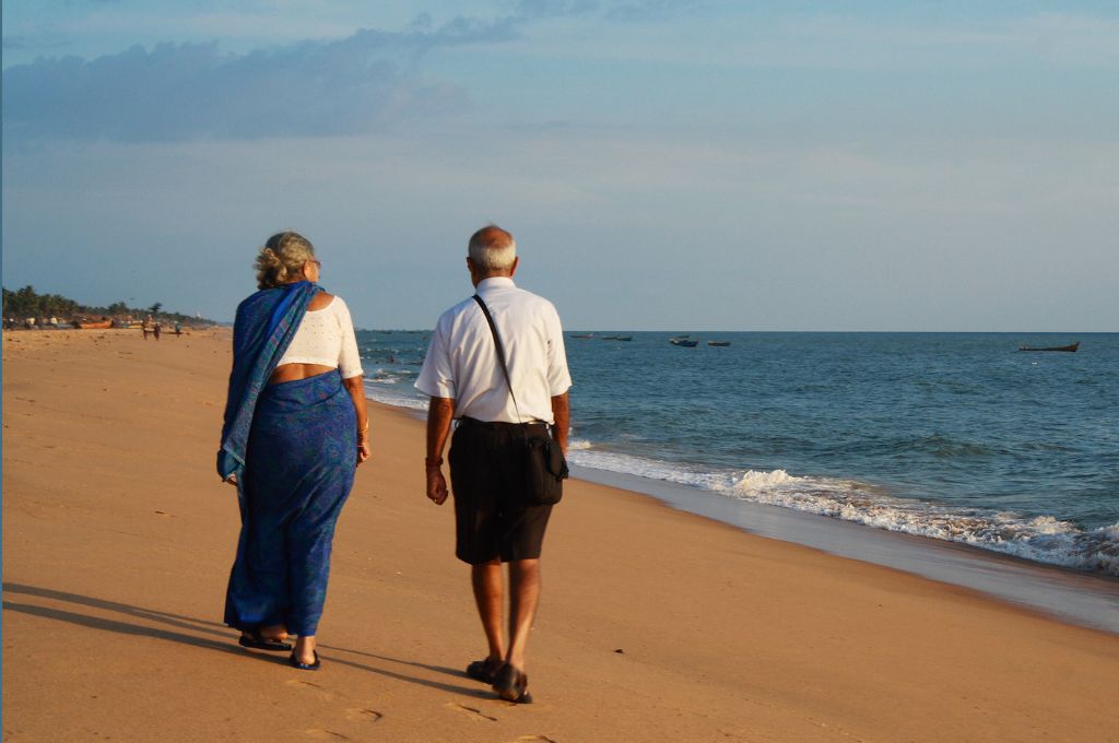 Two elderly people walking on the beach