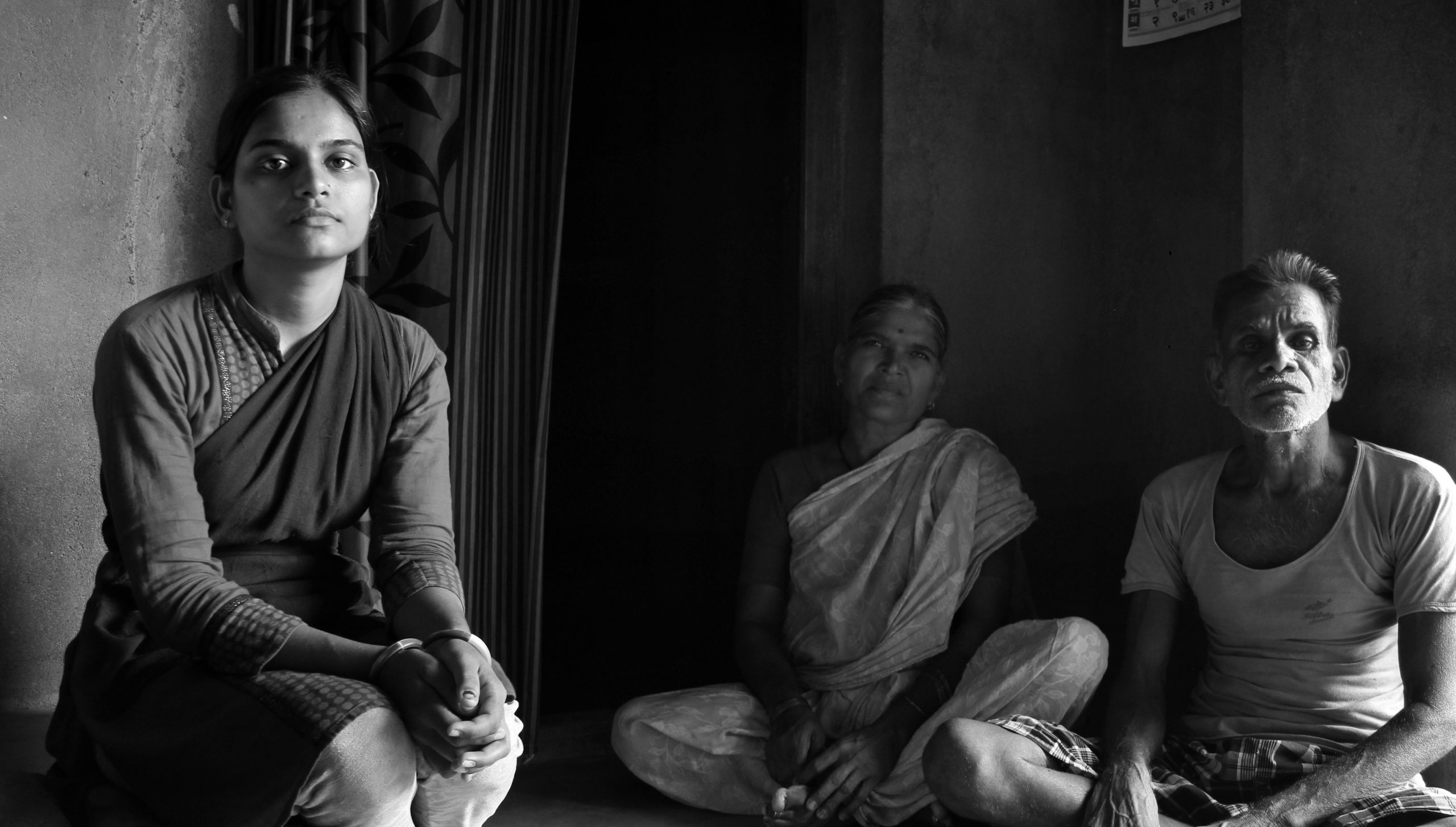 Young Indian girl seated alongside two older Indians-migration